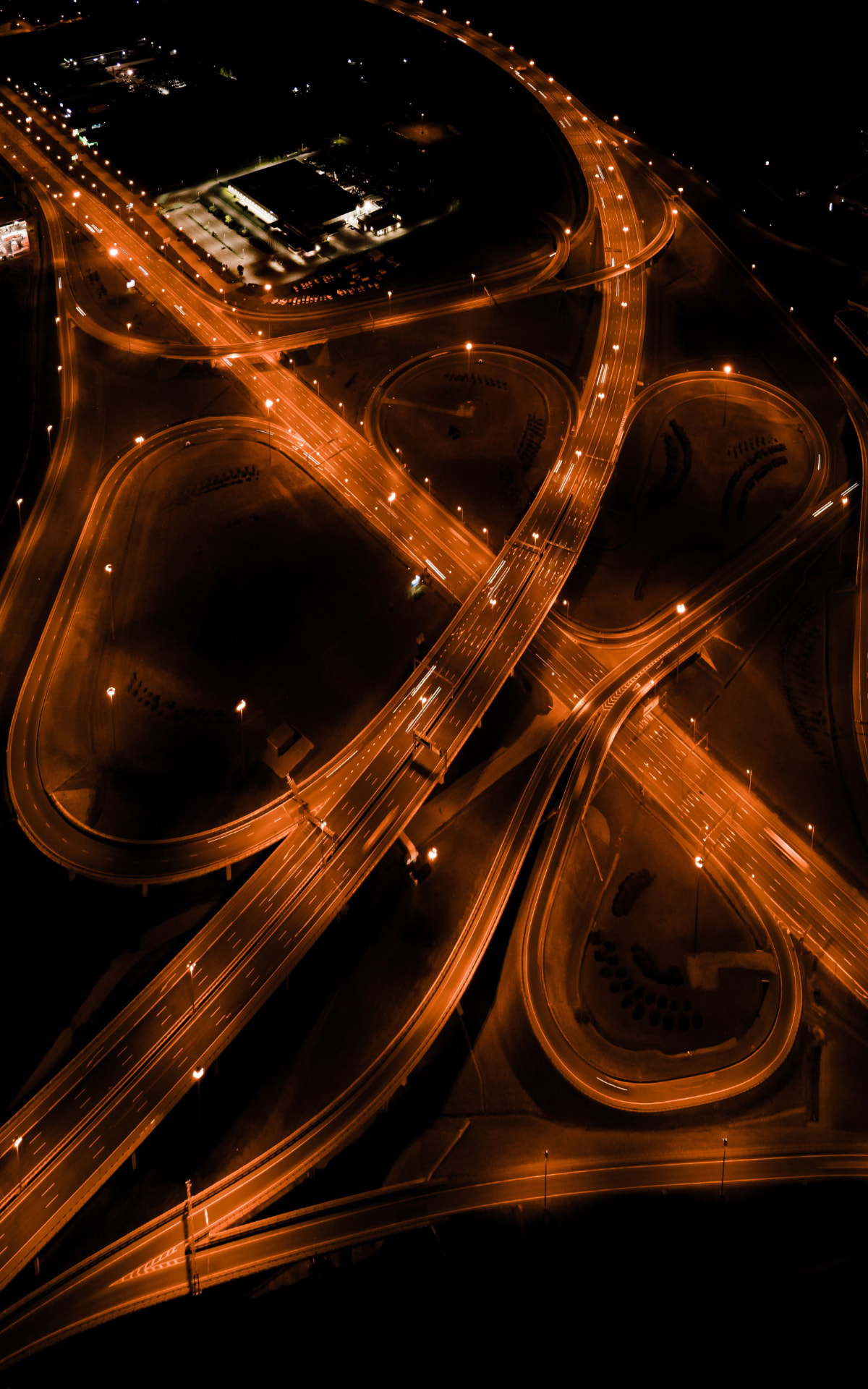 Aerial night view of illuminated highway interchanges near the People Pathways Dubai office in Business Bay